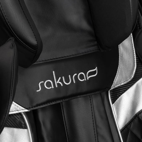Black Sakura Prime 108 massage chair with padded armrests and footrest, showcasing a sleek, modern design in a massage furniture style.