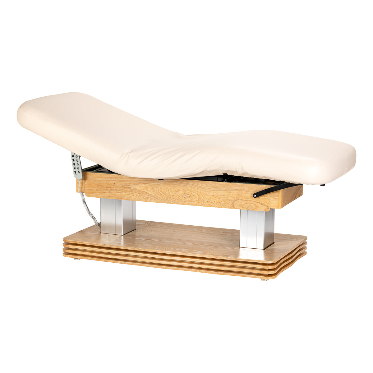 Cream-colored SPA lounger Sillon Comfort with light brown base, used as beauty salon furniture for client relaxation.