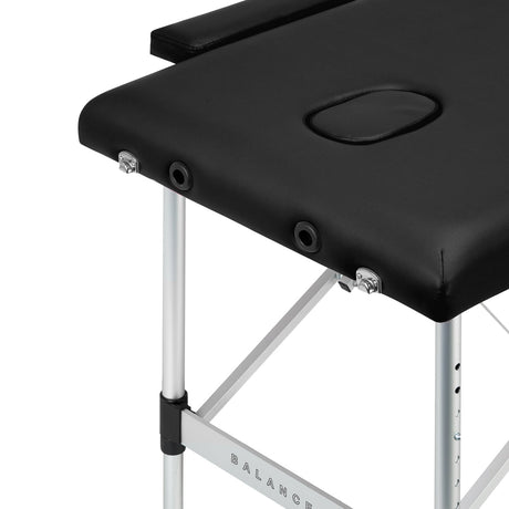 Black BALANCE aluminium folding massage table with two segments, lightweight and portable massage furniture for professional use.