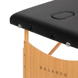 Black BALANCE wooden folding massage table with three segments, featuring a sturdy design and adjustable height for comfort.