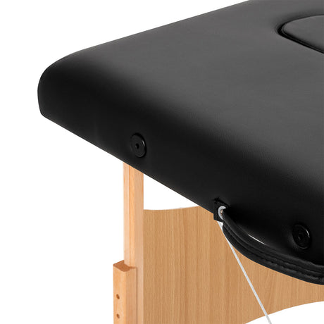 Black BALANCE wooden folding massage table with three segments, designed for professional massage therapy and easy portability.